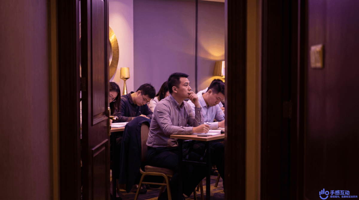 学员们专注手机答题,两人对照屏幕讨论答案